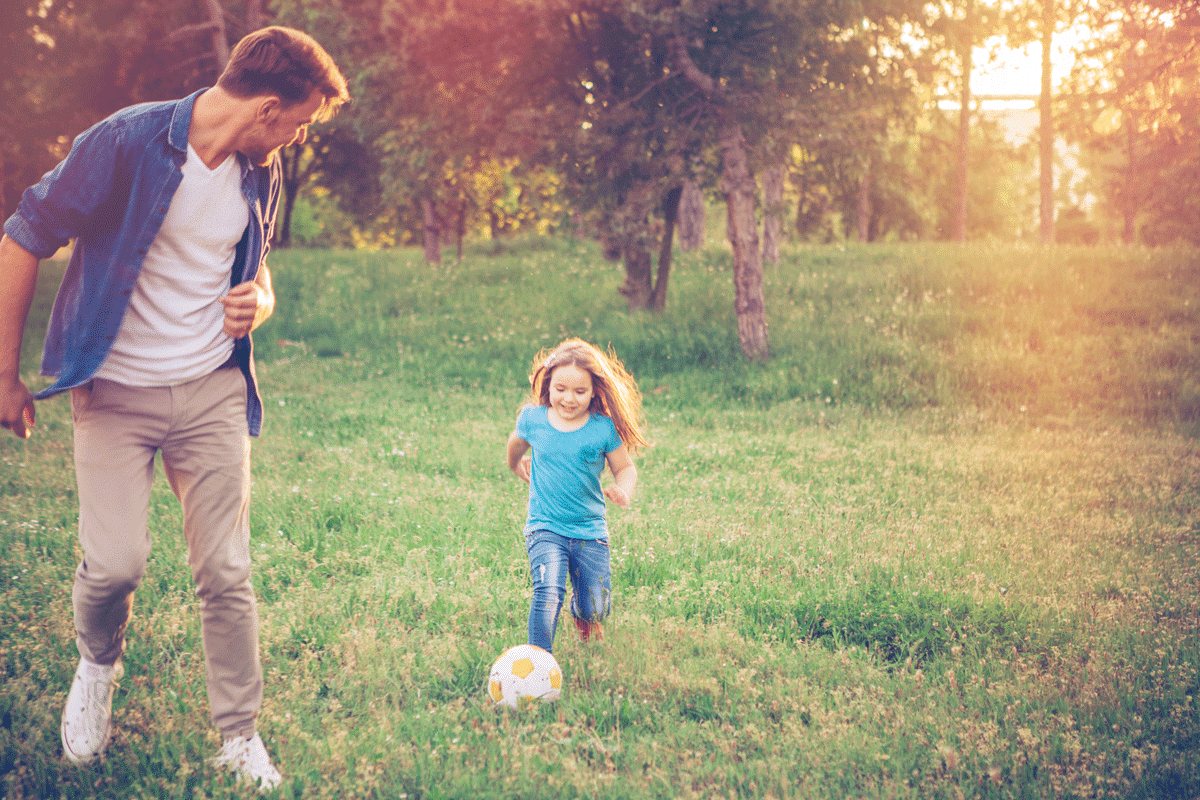 Un père et sa fille jouant au soccer